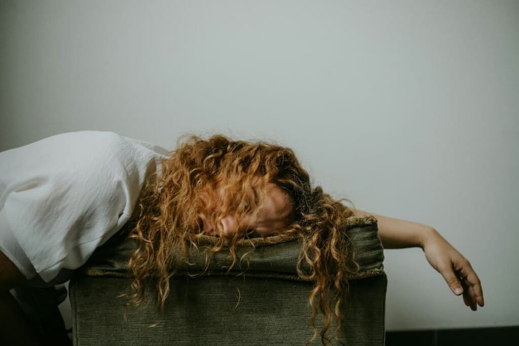 Person experiencing afternoon fatigue and bloating, common signs of liver strain