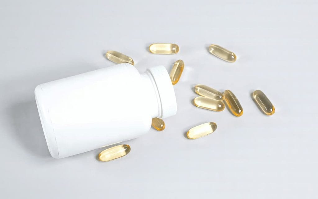 Magnesium supplement capsules and bottle on a wooden surface