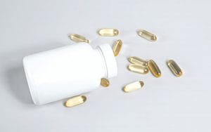 Magnesium supplement capsules and bottle on a wooden surface