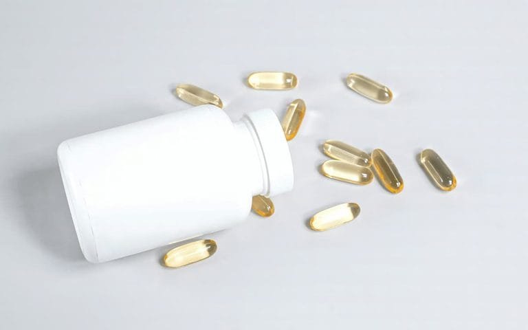 Magnesium supplement capsules and bottle on a wooden surface